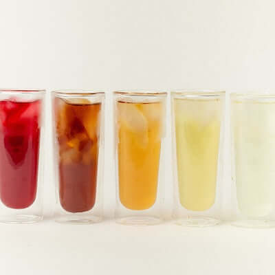 a row of glasses of iced tea on a white background