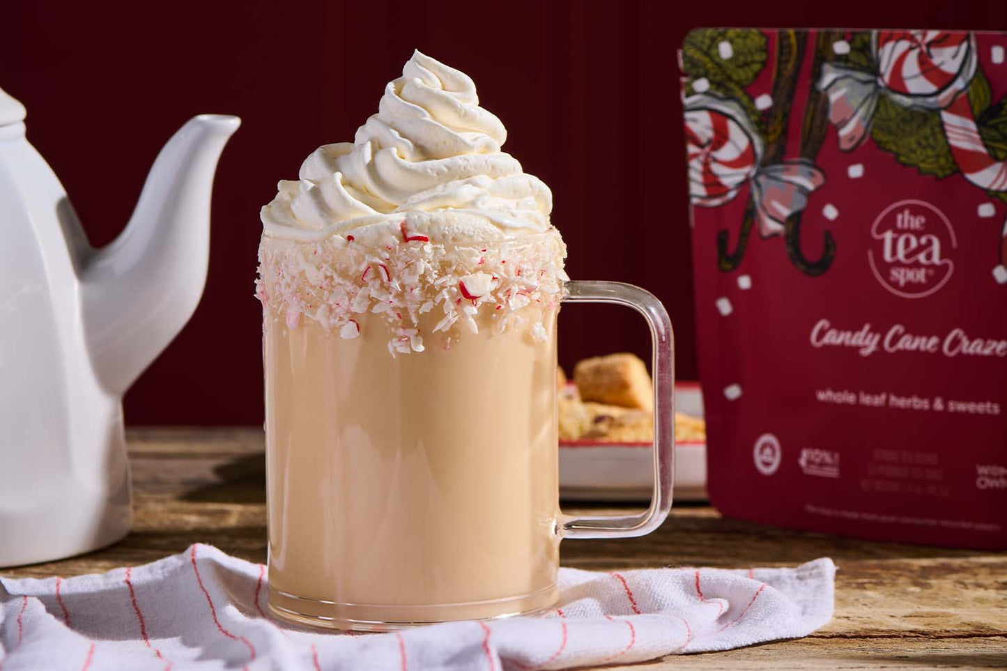 a table displaying a holiday tea latte on display next to a white teapot and a red bag labeled candy cane craze