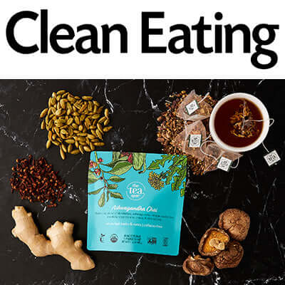 a bag of tea sits alongside ingredients and a brewing cup of tea on a black marble background