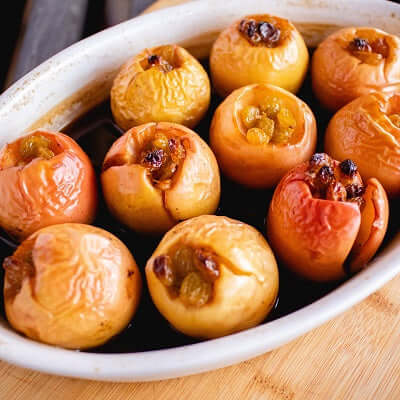 white dish of baked tea apples sits on a wooden surface