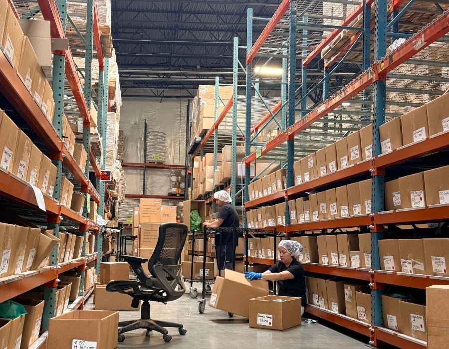 people sit in a warehouse counting tea