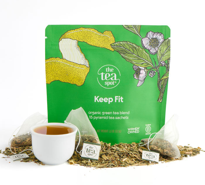 Green tea packaging with lemon and floral design, Keep Fit tea blend, with loose leaf tea and tea bags in front of it. 