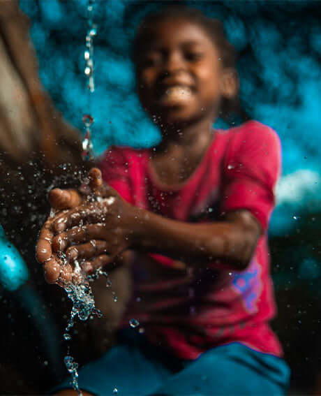 a girl washes her hands in clean water