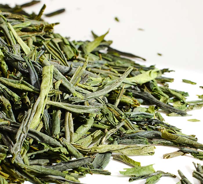 Close-up of lu'an guapian green tea leaves on a white background