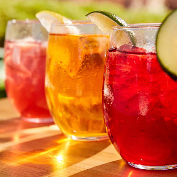 three cups of iced tea sit in the sun