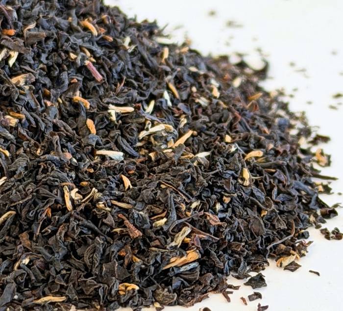 Close-up of black breakfast tea leaves on a white background
