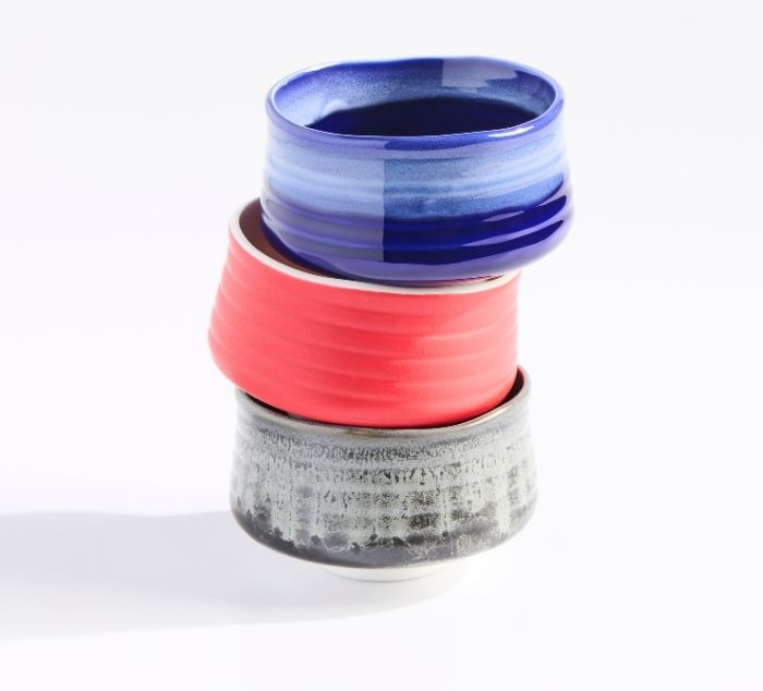three matcha bowls stacked on top of each other, blue, red, and grey