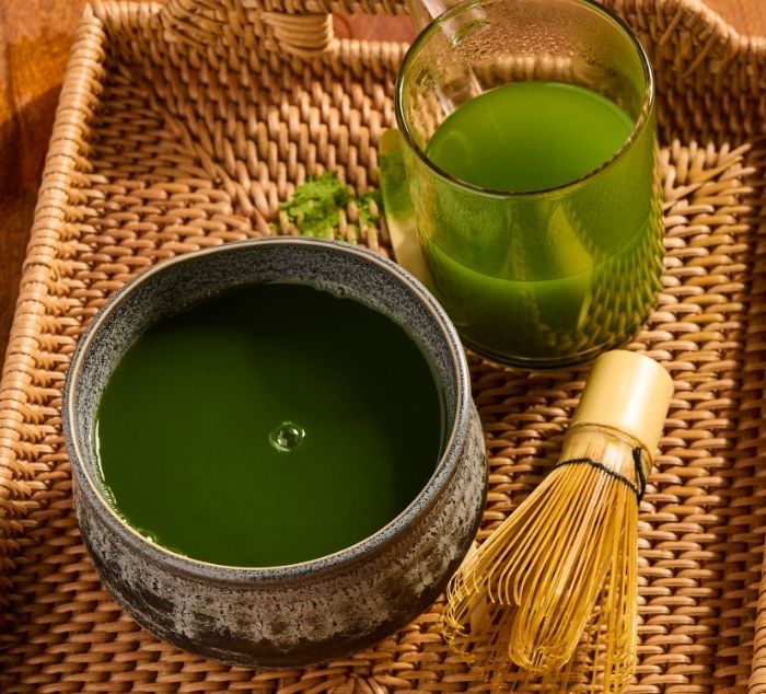 matcha bowl with bamboo whisk and glass of matcha 