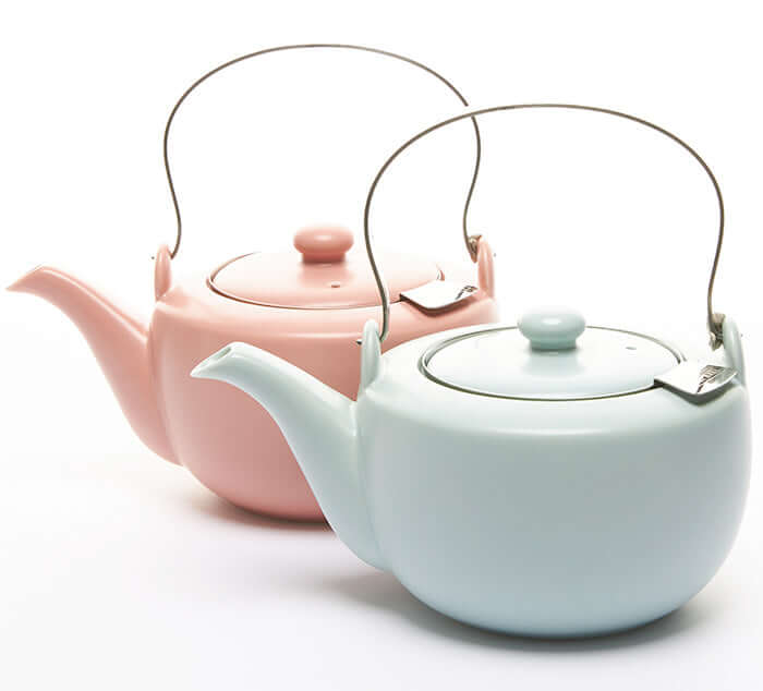 Two satin teapots in pastel pink and blue, designed for loose leaf tea brewing, shown with handles and lids for a 20 oz capacity.
