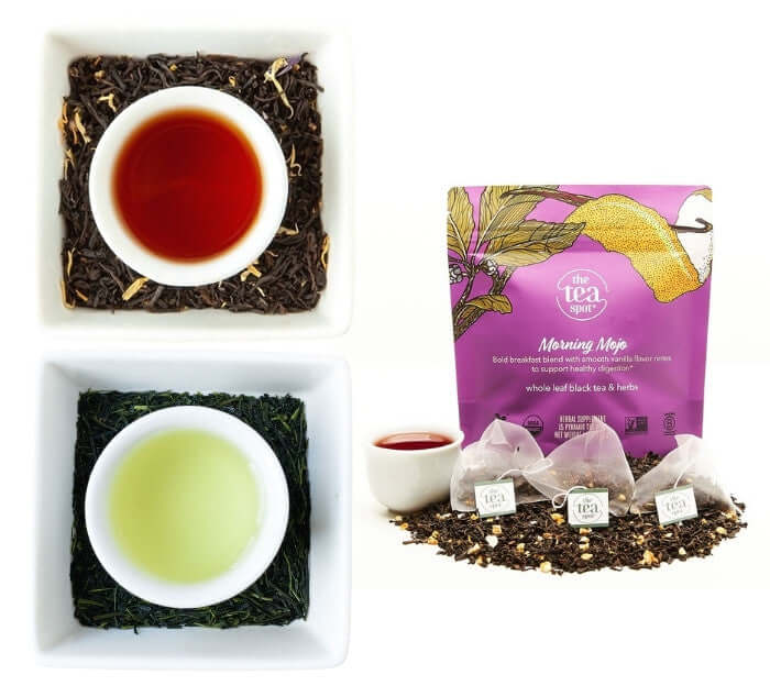 two cups of brewed tea sitting in loose leaf tea with tea bags and brewed tea next to them