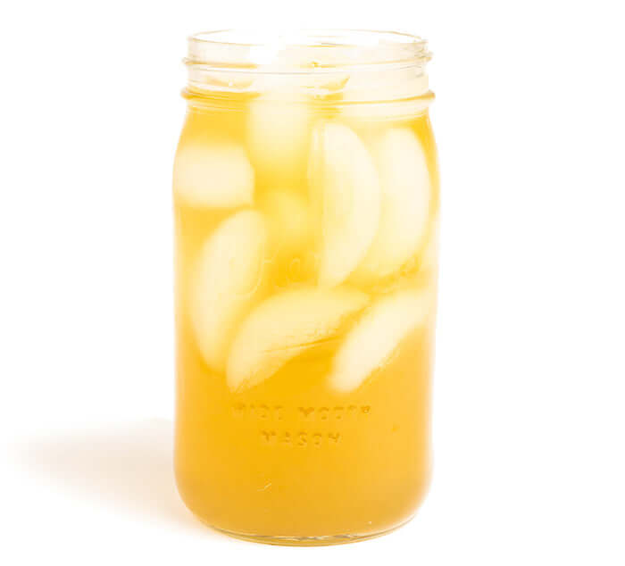 Mason jar filled with iced Boulder Blues green tea, showcasing a refreshing beverage option.