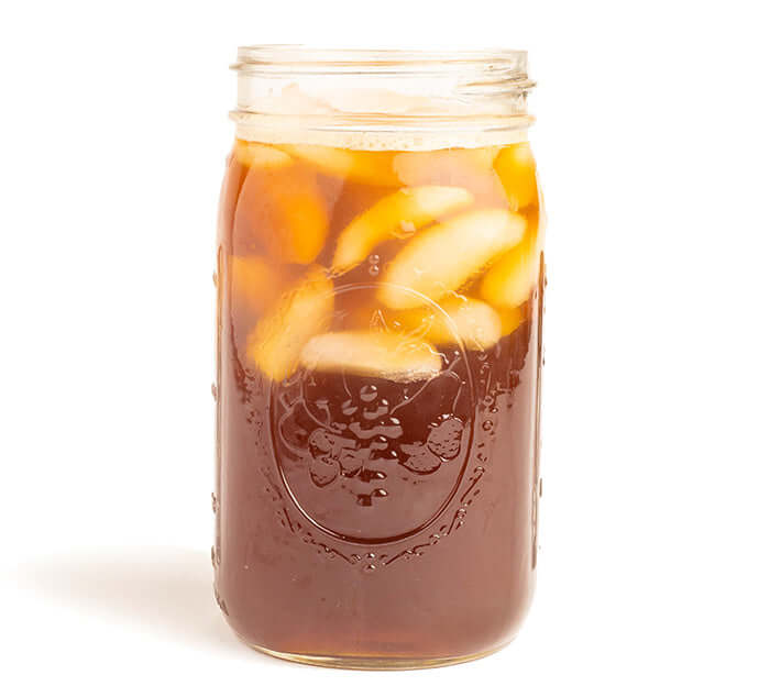 Mango Tango Iced Tea Brewed in a mason jar on a white background