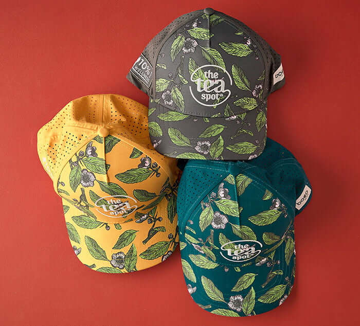 tea spot trucker hats shown in three colors, saffron, teal and charcoal